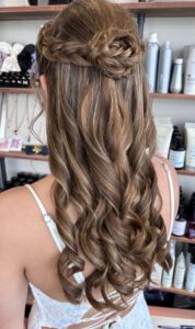 braided half up bun prom hairstyle with soft curls