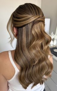 polished twisted half up hairstyle with soft glam waves