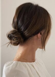 a messy low bun with a volume on top and some face framing locks is a good idea for both medium and long hair