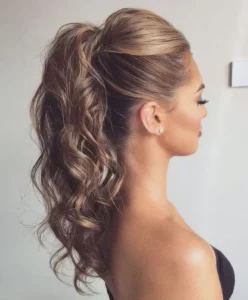 a modern glam hairstyle with a bump on top a wavy high ponytail is a cool idea for a party a wedding or some other occasion