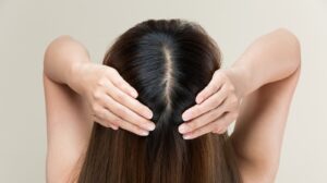 a,woman,is,massaging,her,scalp.